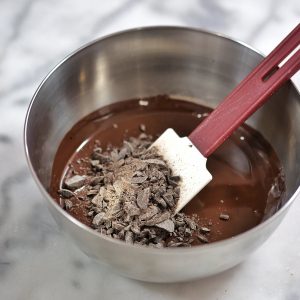 ajout de chocolat haché dans du chocolat fondu